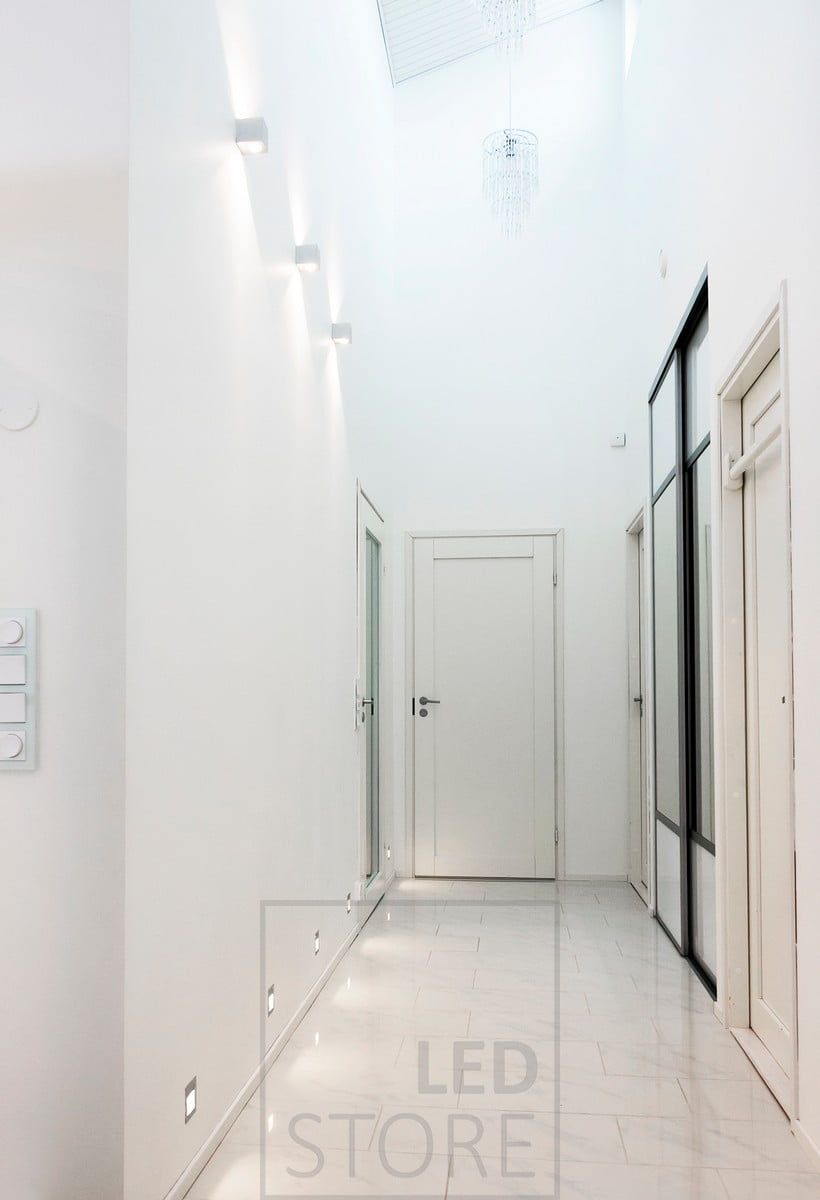 IN-WALL infällda led-väggarmaturer skapar indirekt ljus i korridoren på golvnivå. Genom att ansluta IN-WALL-armaturerna till en närvarosensor får du en funktionell lösning för nattbelysning. Dessa kompletteras av dubbelriktade CUBIC led-väggarmaturer för att accentuera rummets höjd. Ledstore.fi