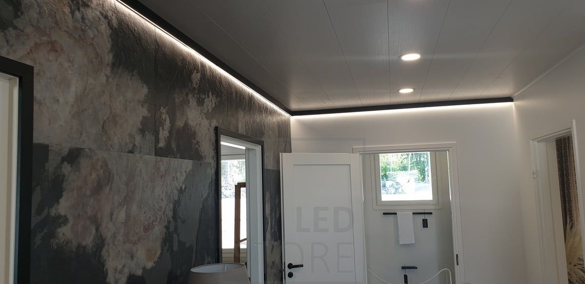 En dekorativ och linjär svart väggprofil med en LED-lampa som ger indirekt ljus. Ledstore.fi