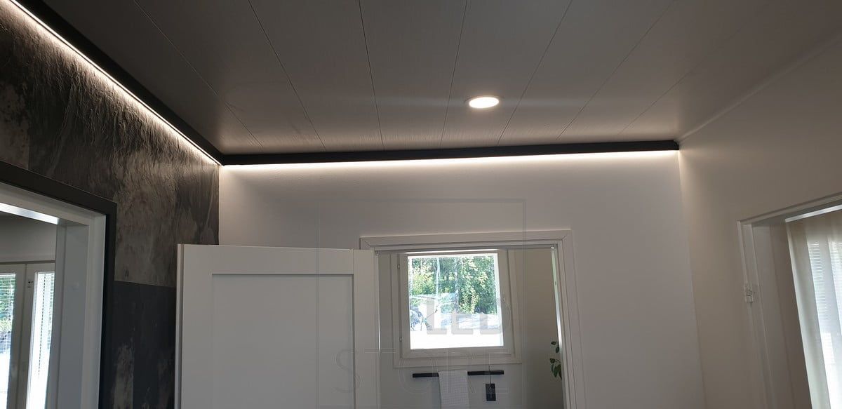 Dekorativ svart väggprofil med LED-ljusramp som ger indirekt ljus. Ledstore.fi