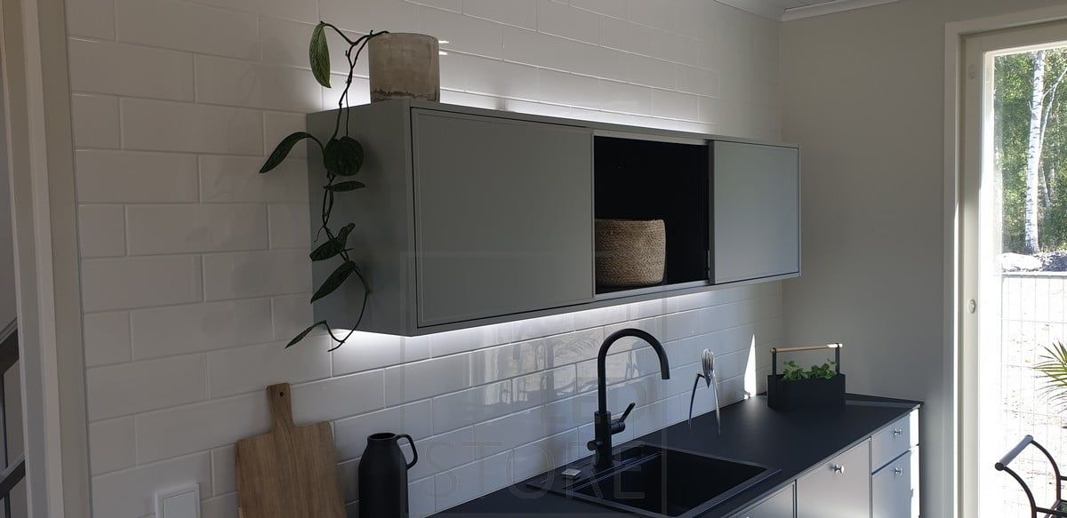 LED-lister belyser skåpets ovansida och bänkskivan och skapar en vacker ljuseffekt som framhäver köket. Ledstore.fi