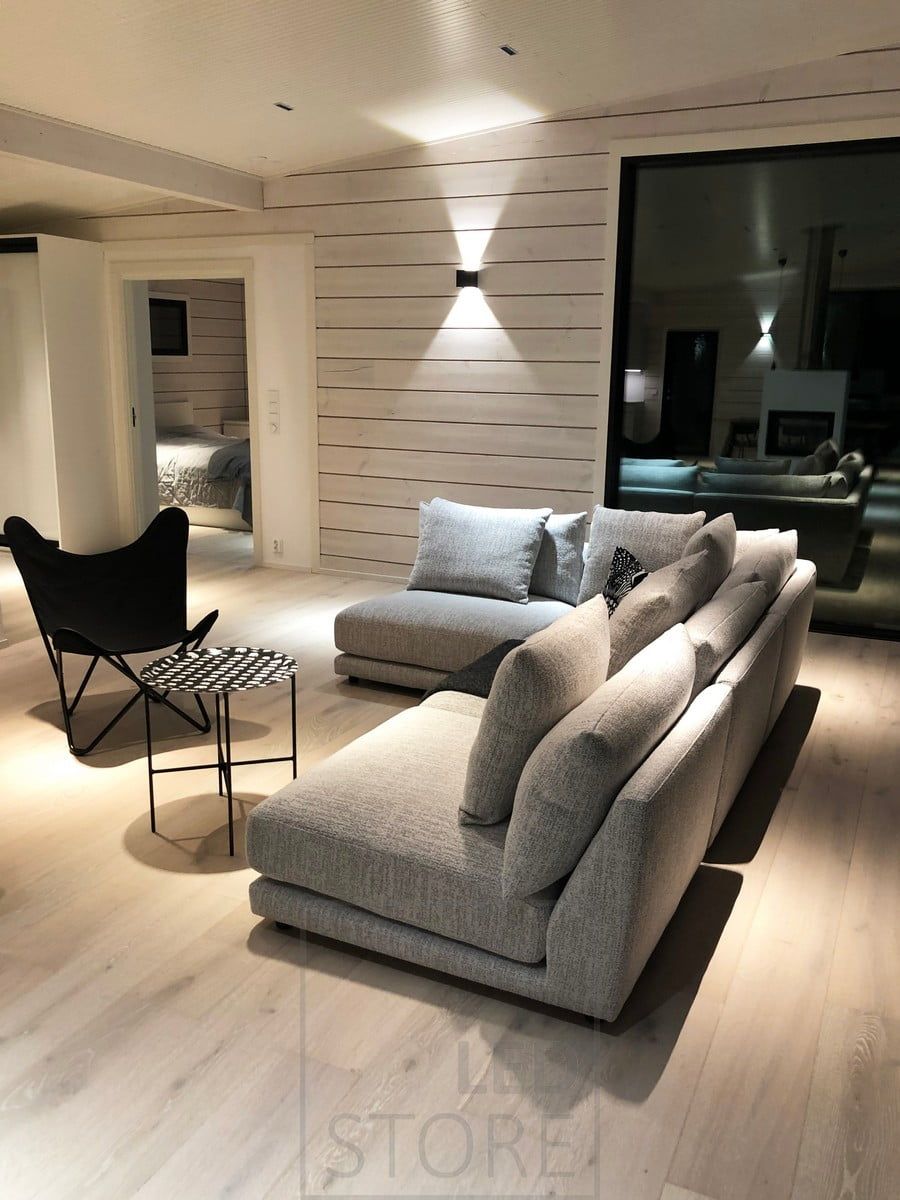 Vardagsrumsbelysning - LINJA-spots i taket i vardagsrummet och en svart FUNK-vägglampa på väggen. Ledstore.fi