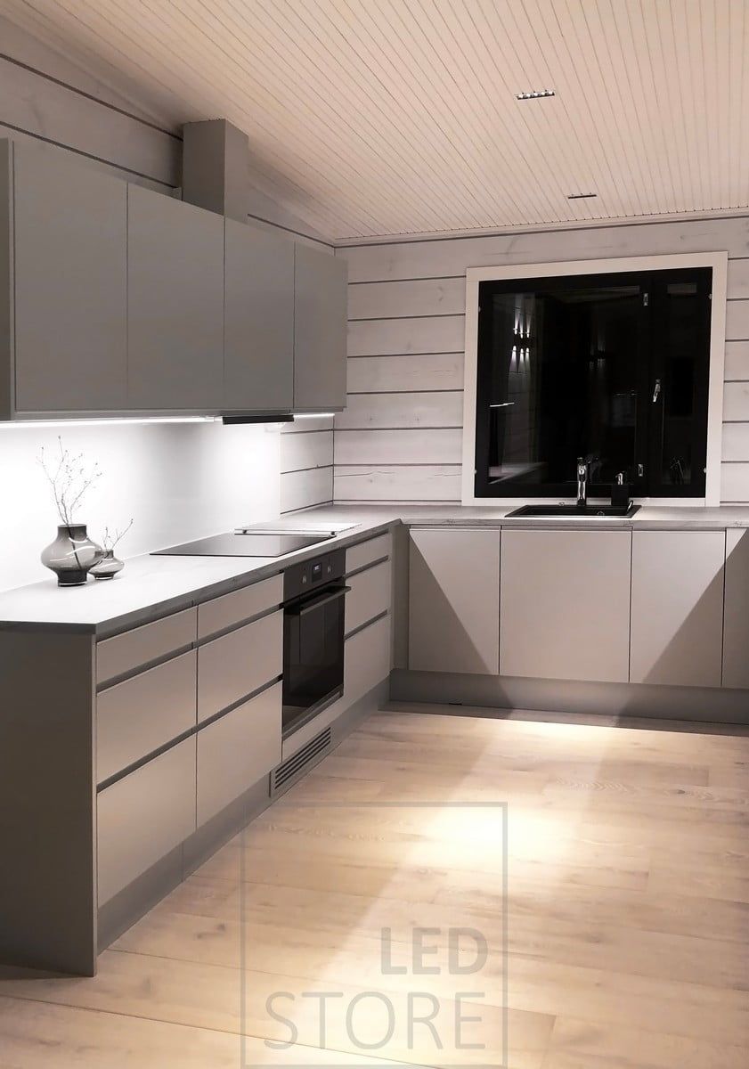 Köksbelysning - längst ner på de övre köksskåpen LED-lampor i aluminiumprofiler som belyser bänkskivorna och LINJA spotlights i taket. Ledstore.fi