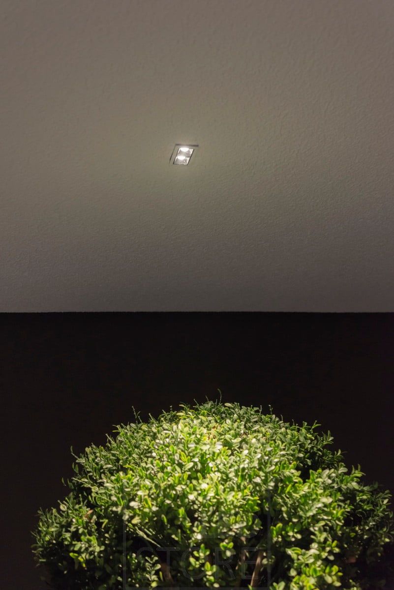 En liten LINJA 2 spotlight på terrassens tak skapar ett stämningsfullt ljus och lyser upp utomhusväxterna. Ledstore.fi