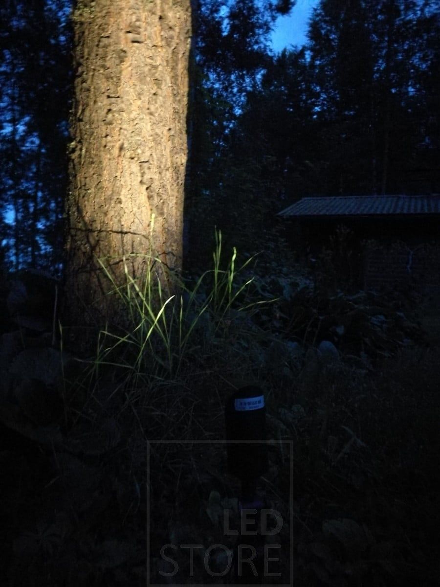 Led markljusspik som belyser ett träd. Lampan har tillräckligt med kraft för att belysa även stora föremål utomhus. Ledstore.fi