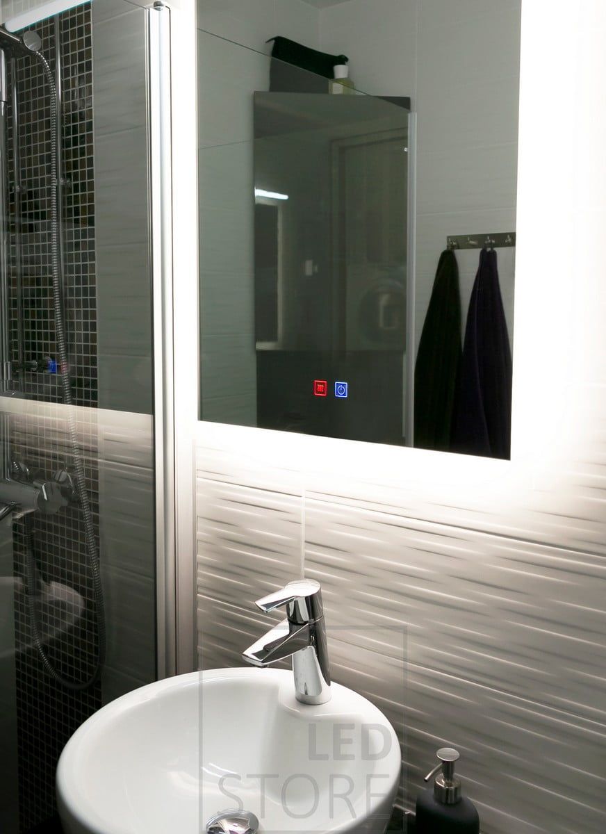 LED-spegeln HALO lyser upp badrummet på ett elegant sätt och framhäver det mönstrade kaklet bakom spegeln. Ledstore.fi