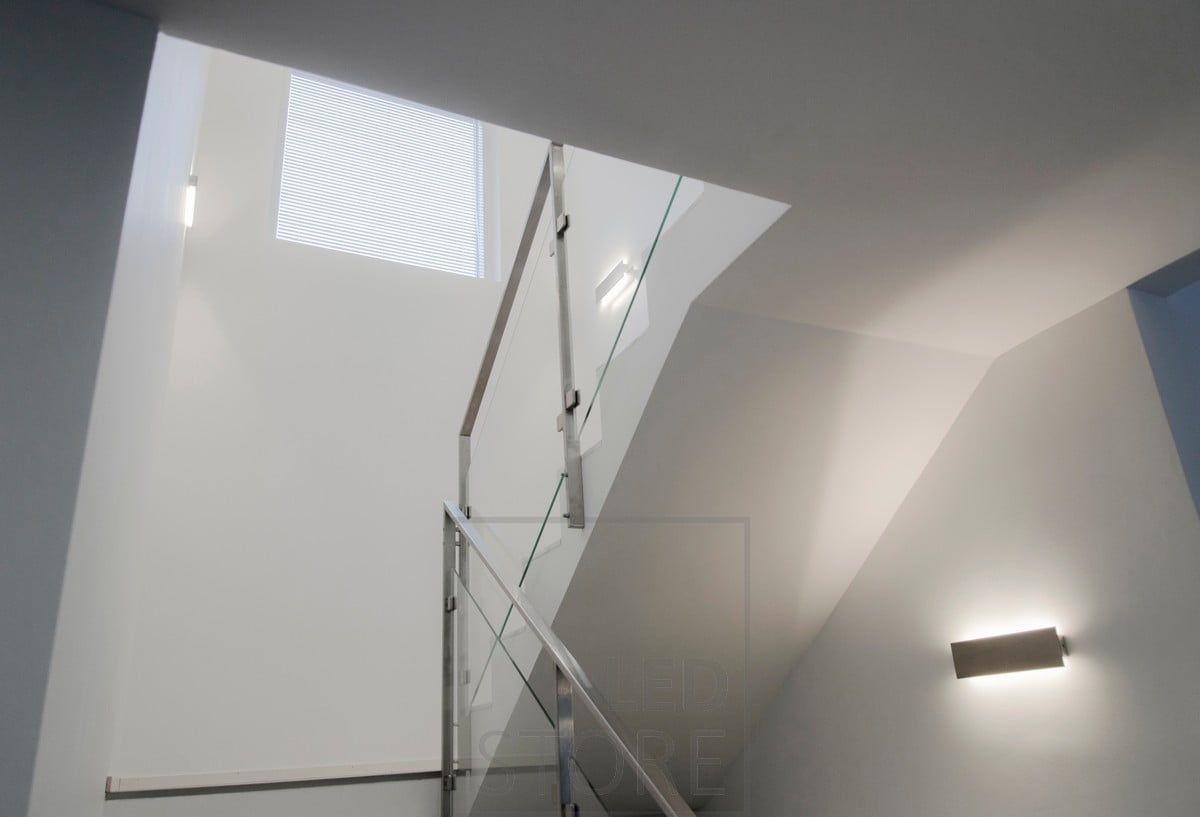 LED-vägglampan STRAIGHT i trapphuset lyser indirekt upp och ner längs väggen och ger rummet en mjuk stämningsbelysning. Ledstore.fi