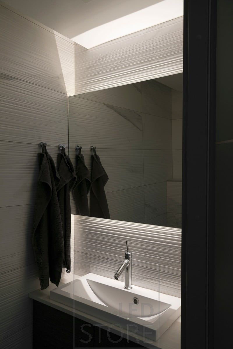LED-lampor bakom spegeln belyser det strukturerade kaklet och spegeln. Ledstore.fi