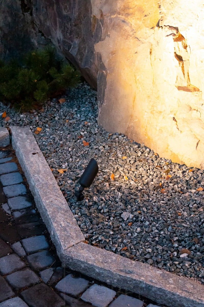 Dekorativ armatur på marken i linje med en sten. Ledstore.fi