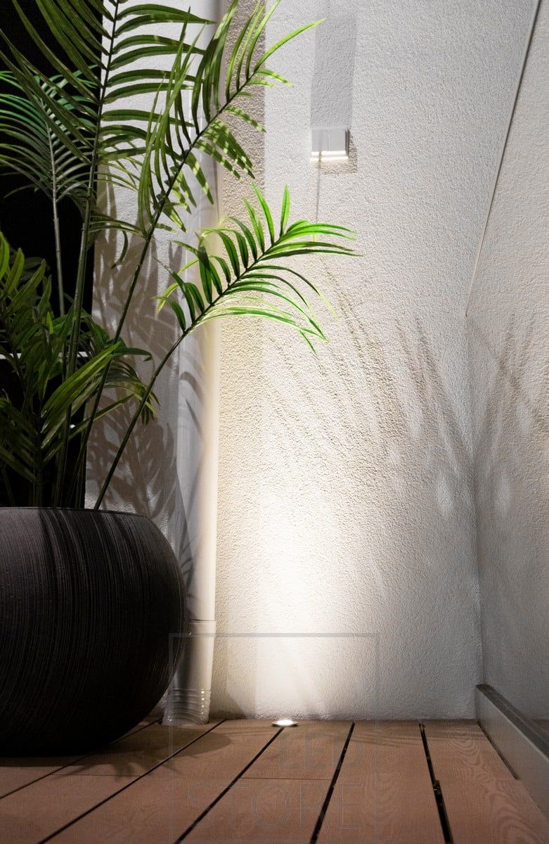 Infälld uteplatsbelysning tillräckligt nära väggen för att skapa en reflekterande yta för spotlighten. Ledstore.fi