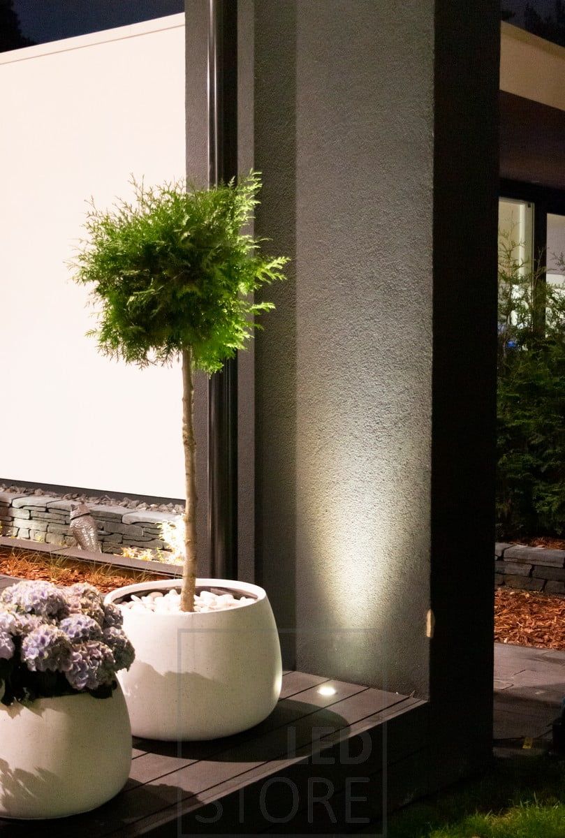 En uppåtriktad spotlight som är inbäddad i en terrazzo använder väggen som en reflekterande yta. Ljuset framhäver även växten framför på ett vackert sätt. Ledstore.fi