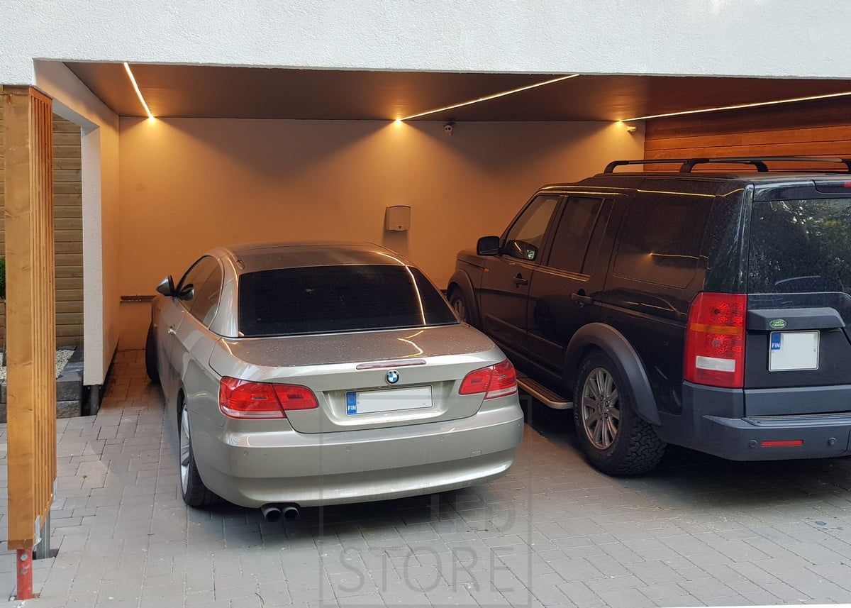LED-list på taket till en carport i en lågprofilerad ytprofil. Placerad så att ljuset inte stannar vid biltaket, utan lyser upp sidorna på bilen så att ljuset är där det behövs. Ledstore.fi