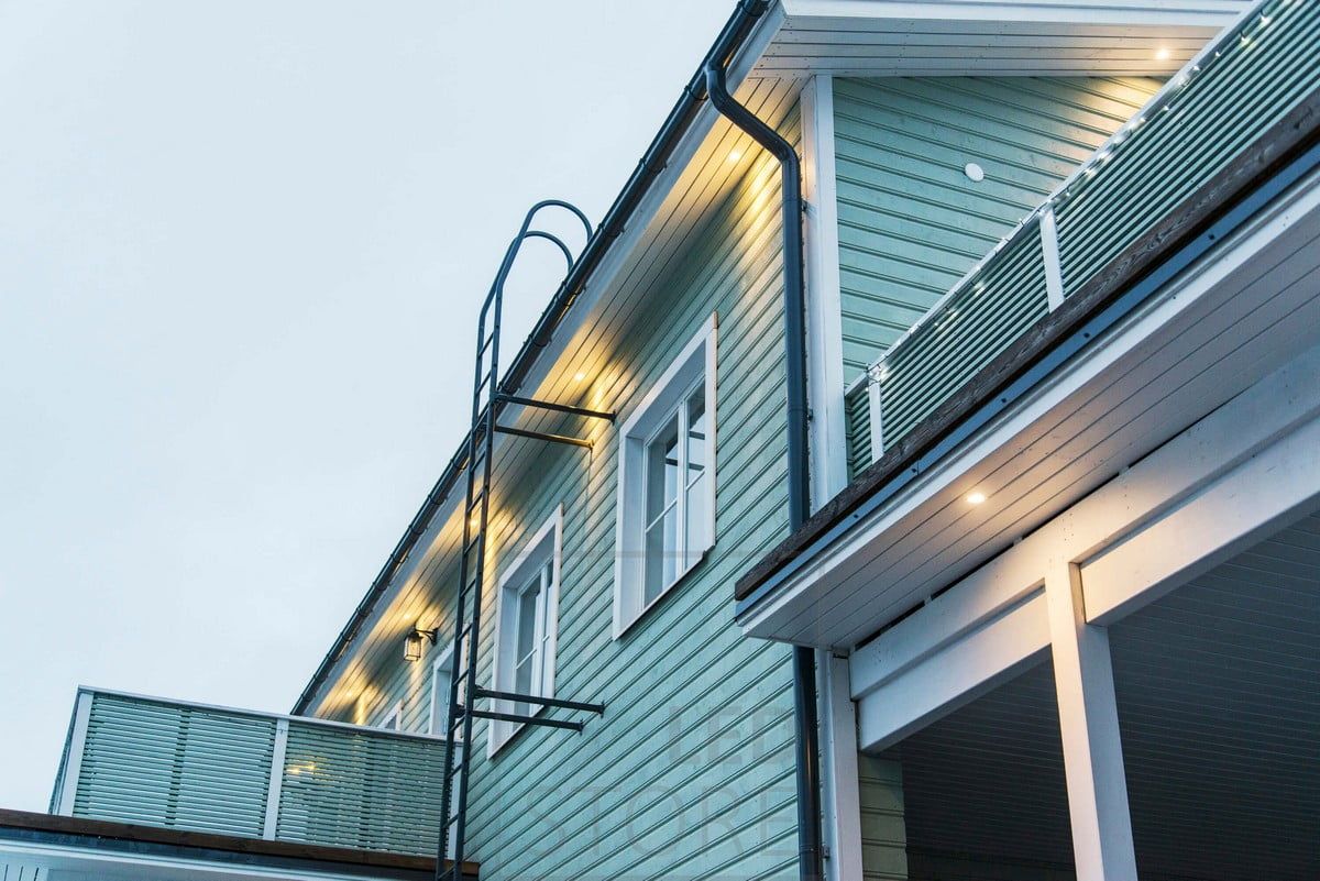 Utvändig belysning av fasaden med strålkastare monterade på en hängränna. Ledstore.fi