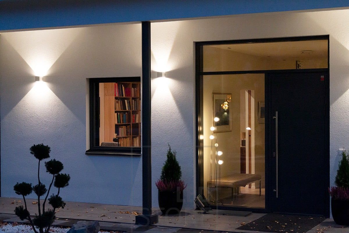 Vita, dubbelriktade FUNK-vägglampor som lyser upp fasaden och entrén. Ledstore.fi