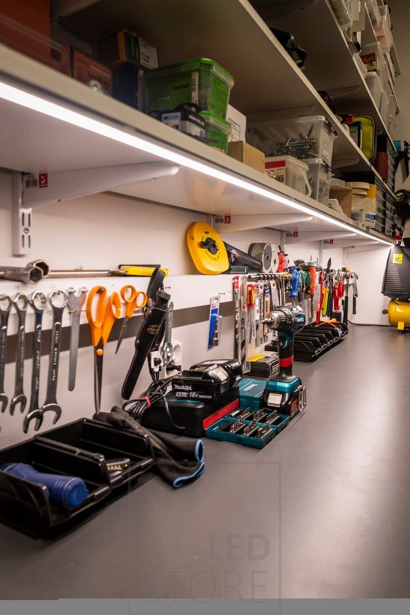 Ledlist på undersidan av en hylla för att belysa en arbetsstation i en lagerlokal. Ledstore.fi