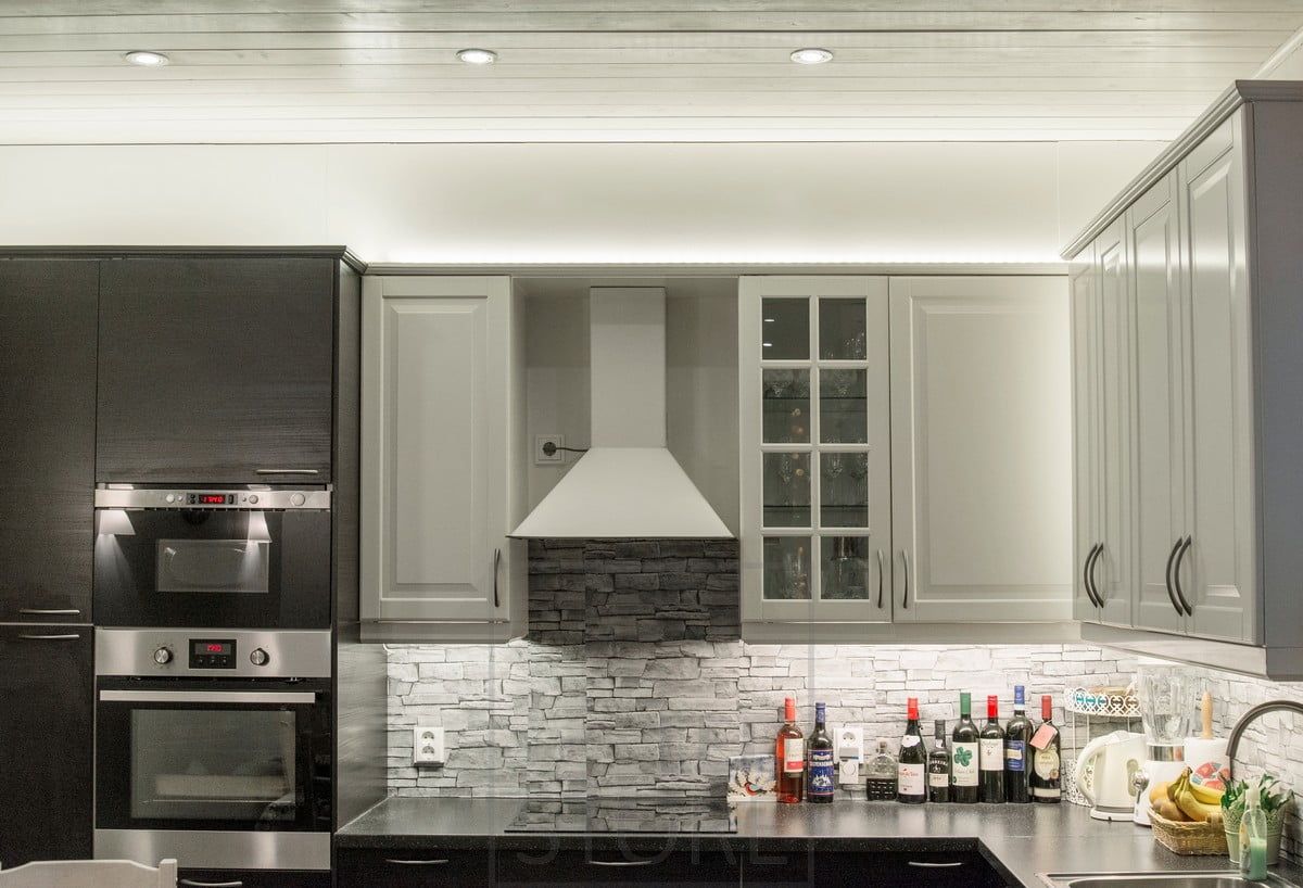 Belysning på köksbänken i kombination med LED-lister ovanpå skåpen och spotlights. Ledstore.fi