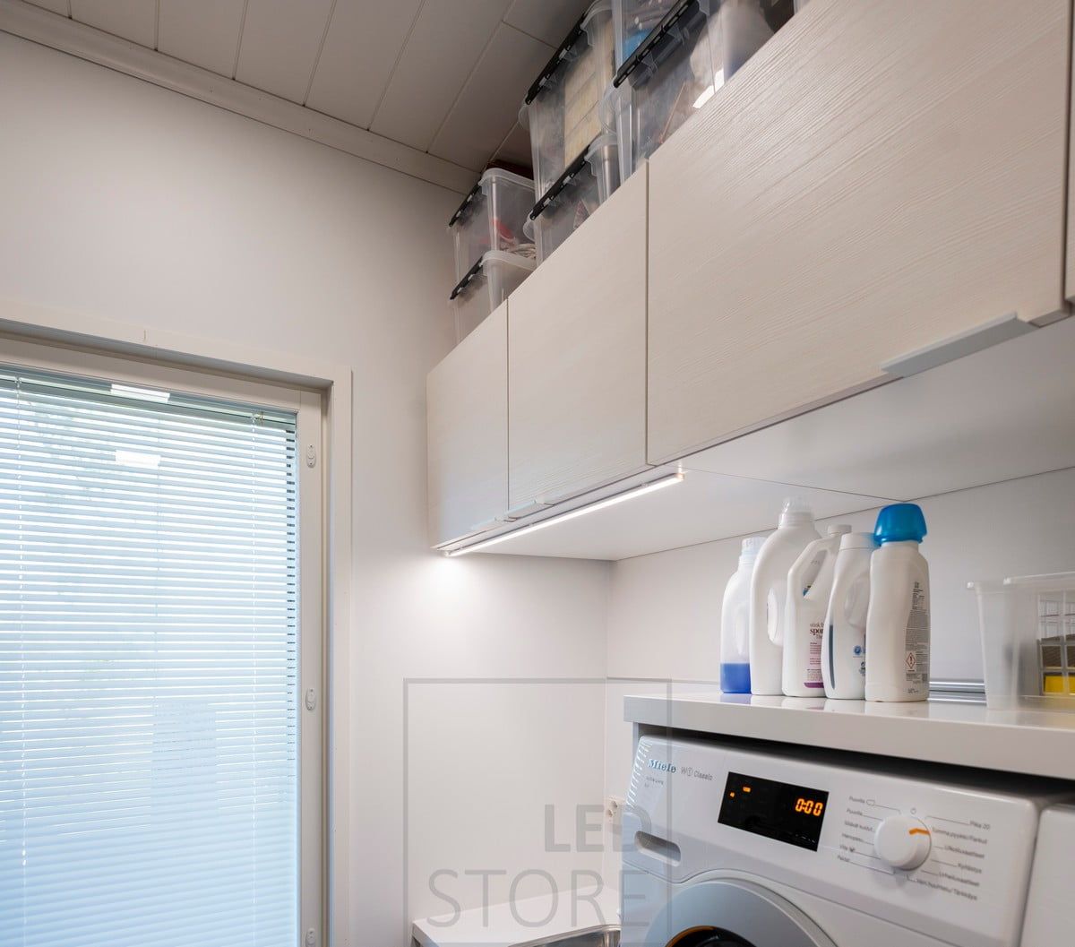 LED-list för extra belysning i tvättstugan, monterad på skåpets framkant. Ledstore.fi