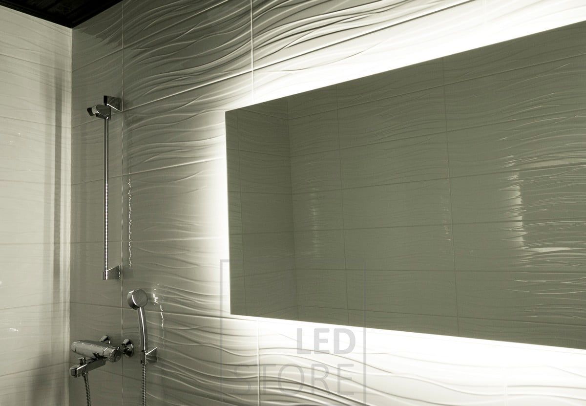 Led-listen, som monterats bakom spegeln, framhäver det mönstrade kaklet och skapar ett stämningsfullt indirekt ljus. Ledstore.fi