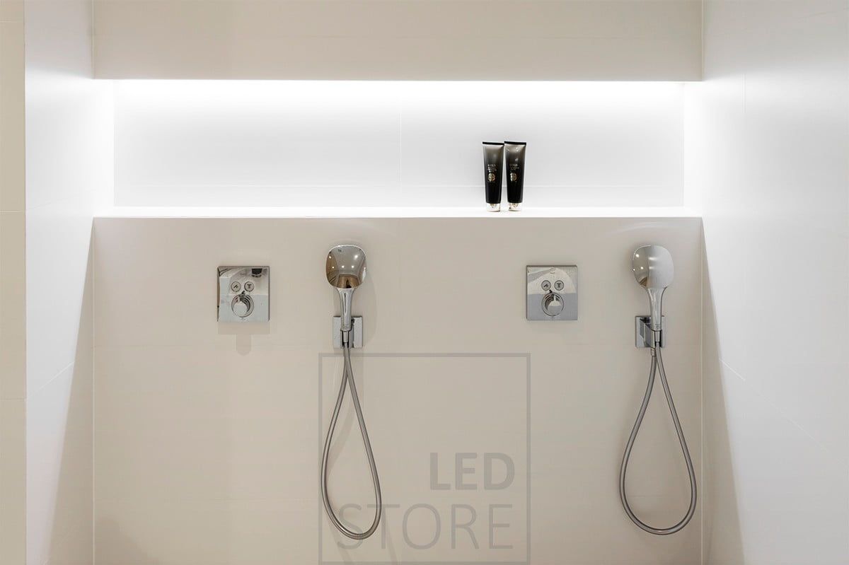 Schampohylla i badrummet, i hyllans övre hörn belyst av en ledlist. Ledstore.fi