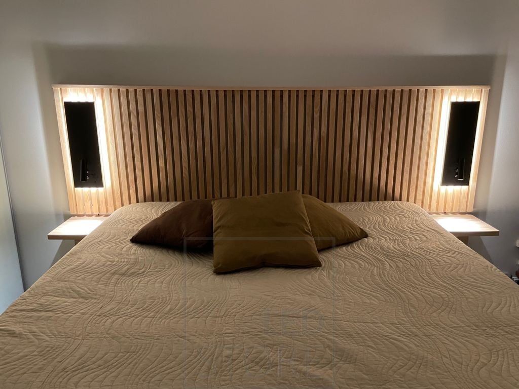 Svarta NIGHT vägglampor vid sängens huvudända. Armaturen har ett riktat läsljus och ett indirekt stämningsljus. Ledstore.fi