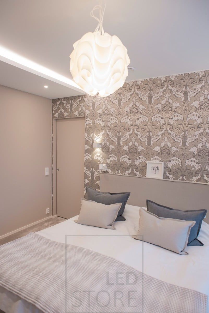 Ett sovrum med mångsidig och hotellliknande belysning. Indirekt belysning, spotbelysning och en dekorativ pendellampa i mitten av rummet. Ledstore.fi