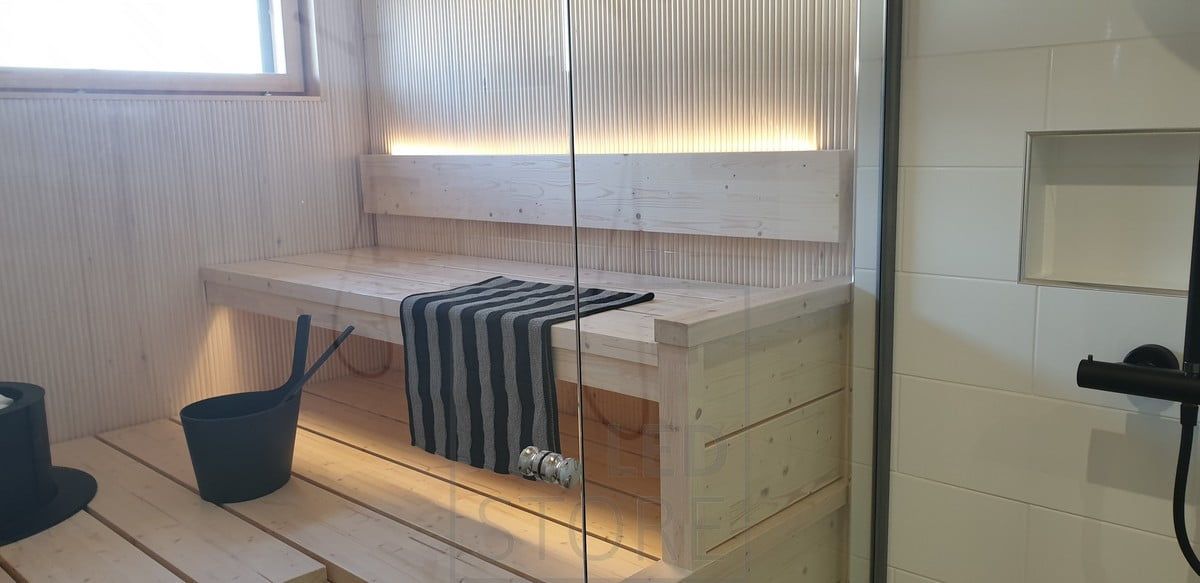 LED-list på baksidan av bastuns ryggstöd ger stämningsfullt ljus uppåt och nedåt under taket. Ledstore.fi