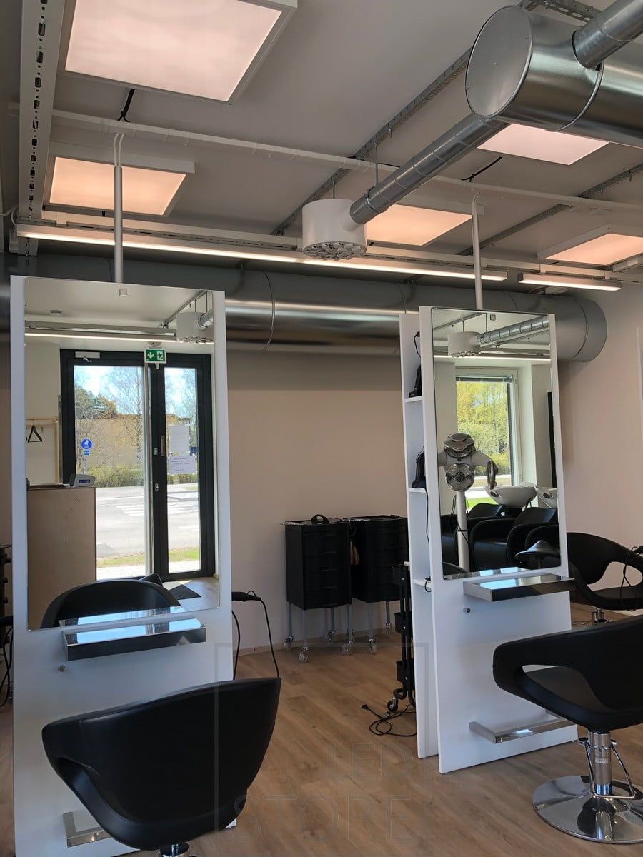 En 600x600-panel i taket på frisörsalongen för att belysa och skapa en enhetlig, effektiv och anpassningsbar belysning. Armaturen kan antingen monteras infälld i taket eller utanpåliggande. Ljuskällan har en öppningsvinkel på 110 grader, så ljuset lämnar inga skuggor i rummet, utan lyser upp hela utrymmet jämnt. Ljuset är dimbart och färgtemperaturen kan justeras. Ledstore.fi