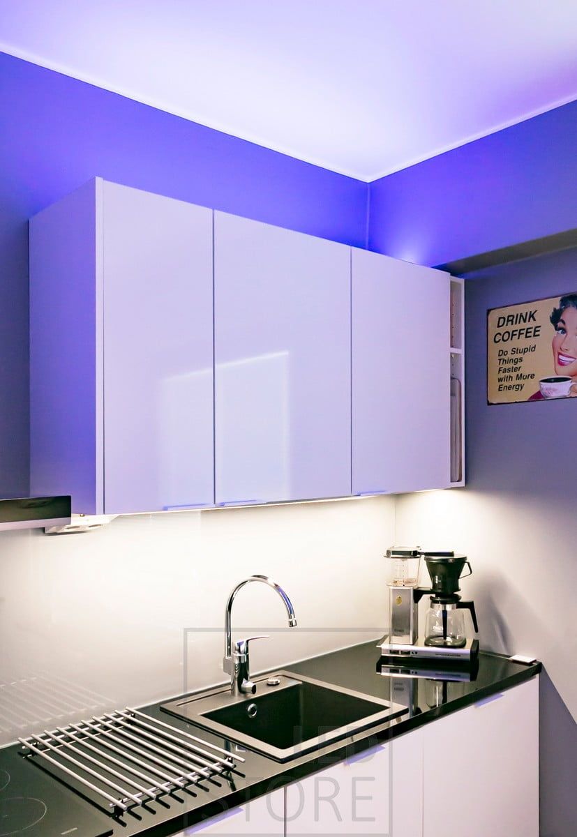 Anpassningsbar stämningsbelysning i köket ovanför skåpen med RGB+W-ledlist, ljusfärgerna kan justeras steglöst med trådbunden eller trådlös styrning. Ledstore.fi