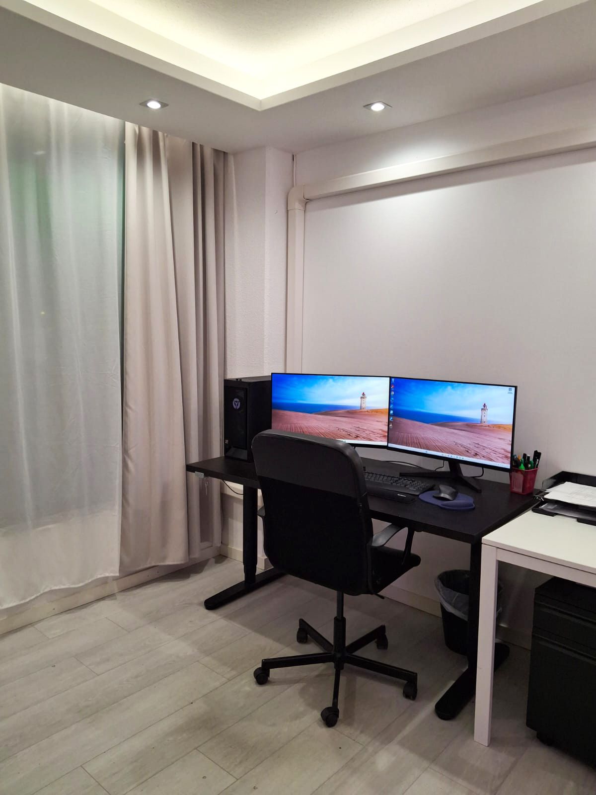 Arbetsrum med datorskrivbord och skrivbordsstol, nedsänkt tak. Spotlights och indirekt ljus från led-lister installerade i undertaket.