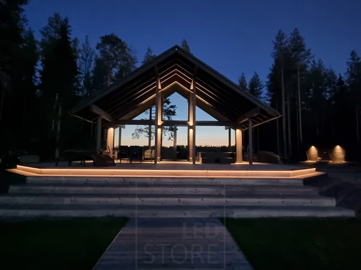 Mångsidig utomhusbelysning med LED-lister i trappan och vägglampor. Vägglampor som lyser i två riktningar på en hög punkt och i en riktning på en lägre punkt. Ledstore.fi