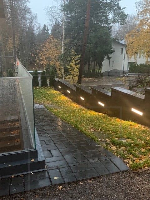 Ledband inbäddat i en vägg skapar stämningsfull belysning på innergården. Ledstore.fi