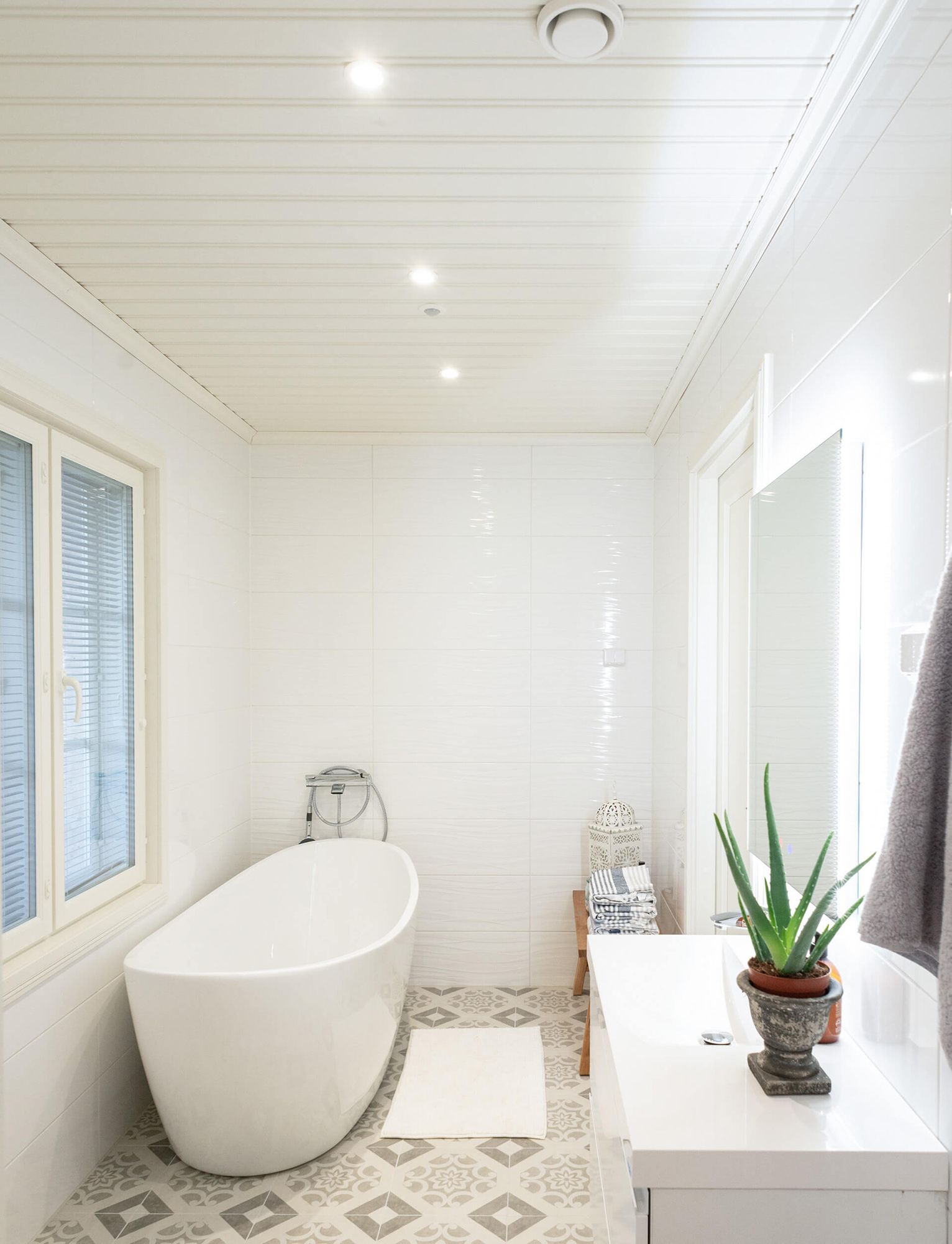 Spotlights i badrumstaket och en ljus spegel som lyser upp handfatet.