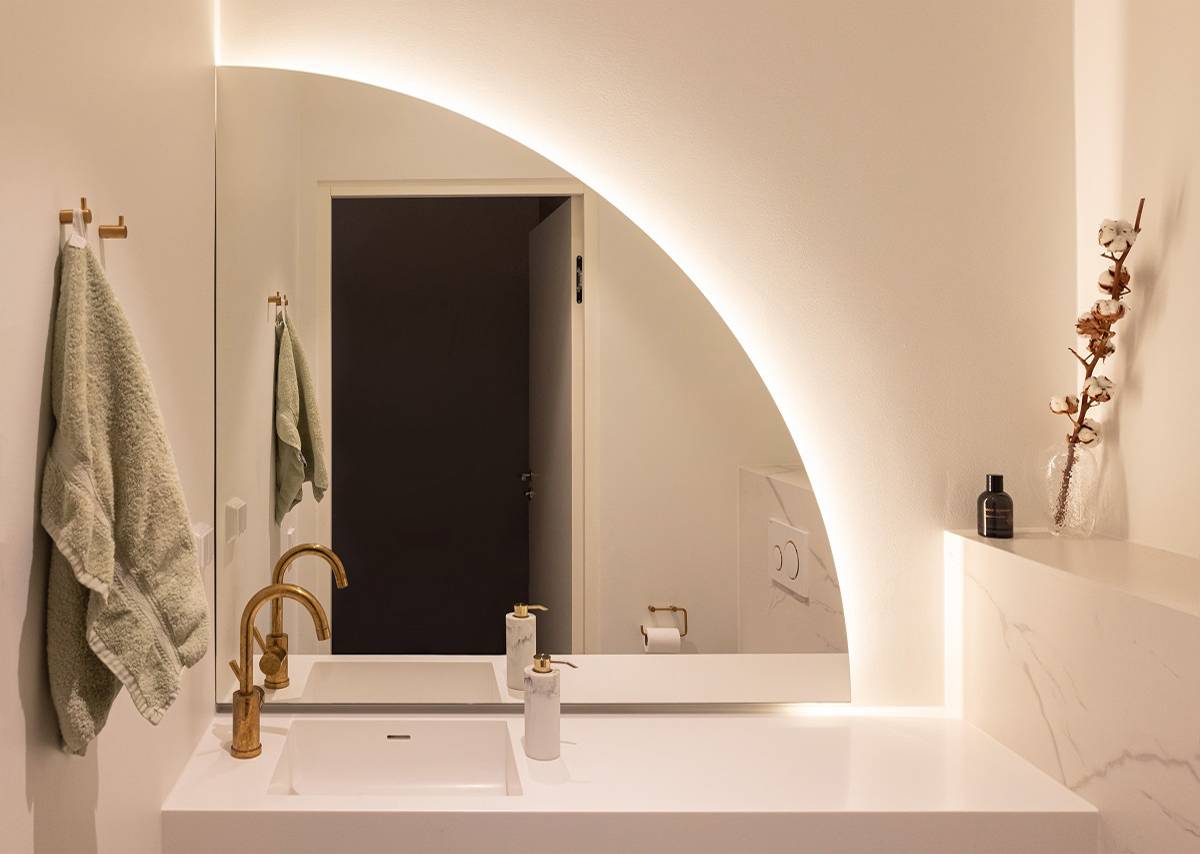 Referenser House Eteläaho, badrumsspegel LED-belysning bakom en böjd spegel.