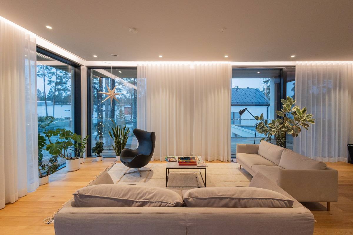 Referensprojekt I vardagsrummet i House Eteläaho finns LED-remsor och LED-spots runt rummets kanter.