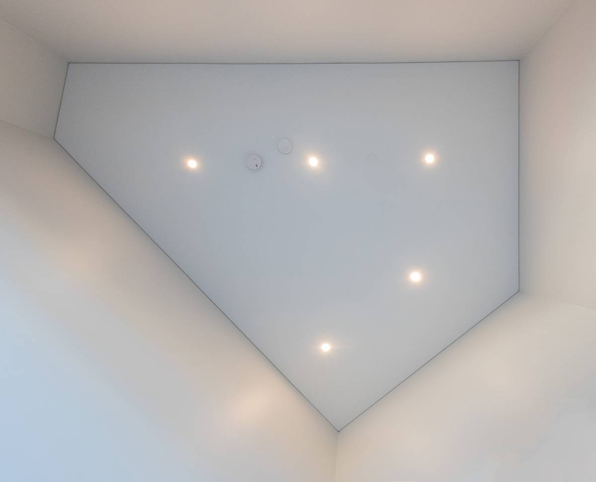 Led-spots i taket, sett direkt underifrån. Spottarnas placering kan anpassas till rummets form, som i detta femkantiga rum.