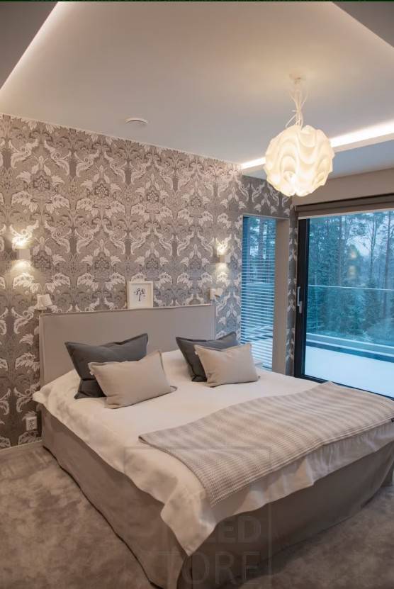 I det här sovrummet har XL-Cubic vägglampor installerats på väggen och en LED-remsa i ljusstolpen för att skapa atmosfär. Taklampan ger en dekorativ touch och mer ljus till rummet.