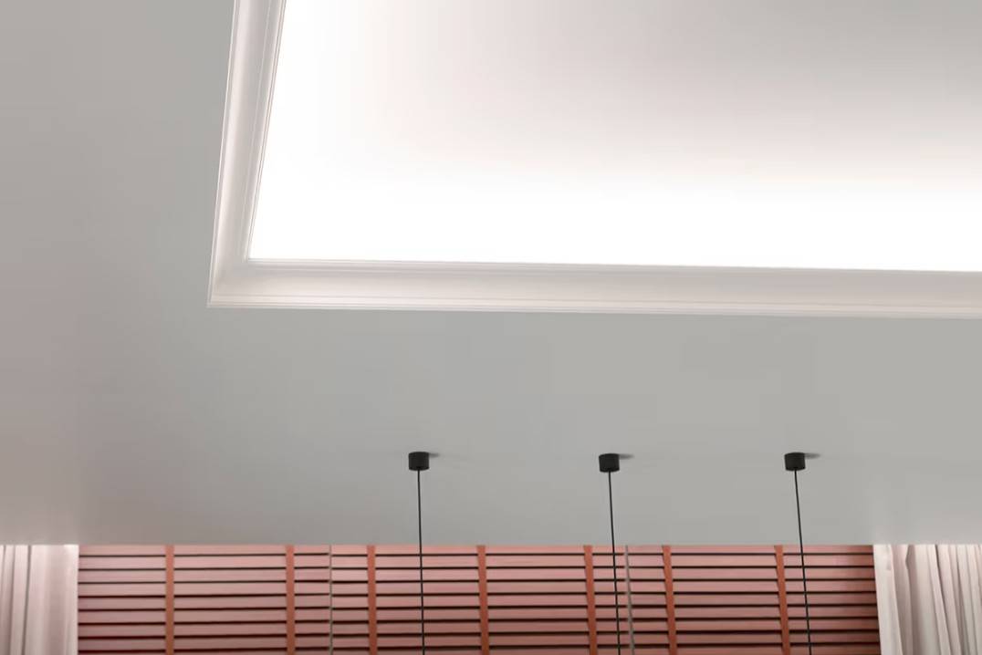 Ett funktionellt belysningspaket för vardagsrummet. LED-lamporna på takhyllan lyser upp mot taket och nedåt mot gardinerna.