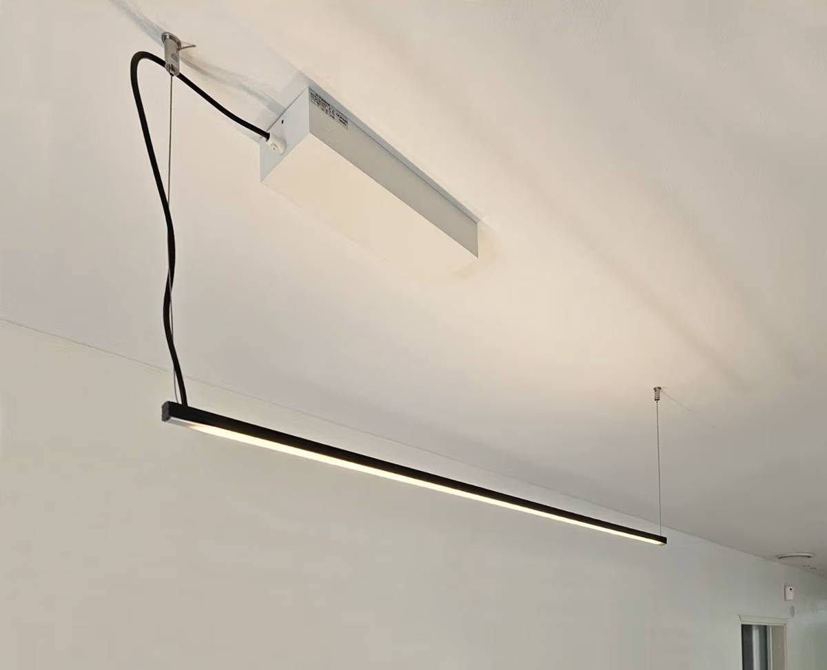 Den moderna linjära armaturen Luks hänger från det vita taket och uppfyller kraven i standarden EN 12464-1 på LedStore.fi.