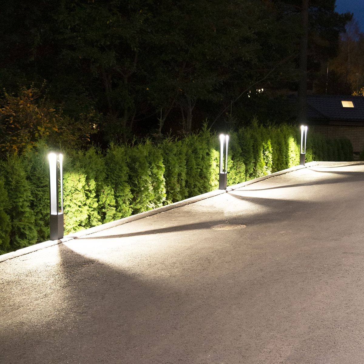 Pelarlampor vid tomtgränsen lyser upp innergården.