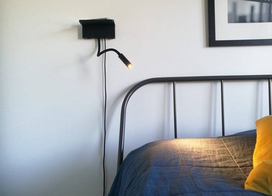 NIGHT natt- och läslampa vid sängens huvudända. Lampan har både trådlös laddning och en USB-port för laddning av din telefon. Ledstore.fi