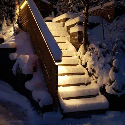 De snötäckta utomhustrapporna reflekterar ljuset från balustraden.