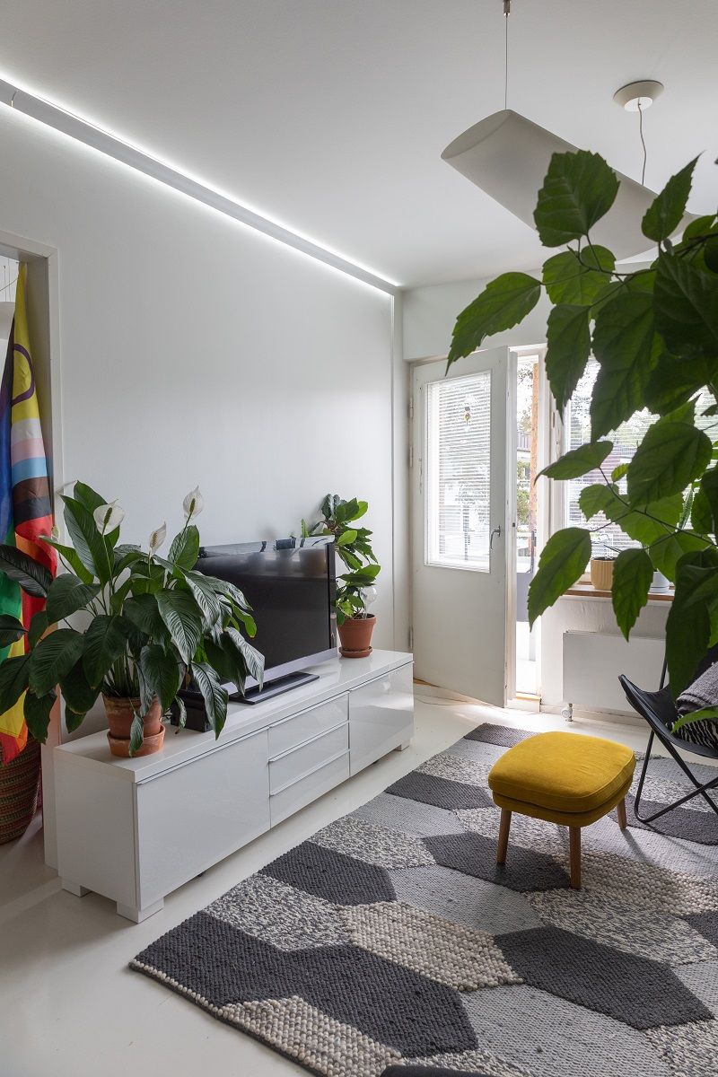 Tvåvägs belyst led-profil i taket i ett vardagsrum.