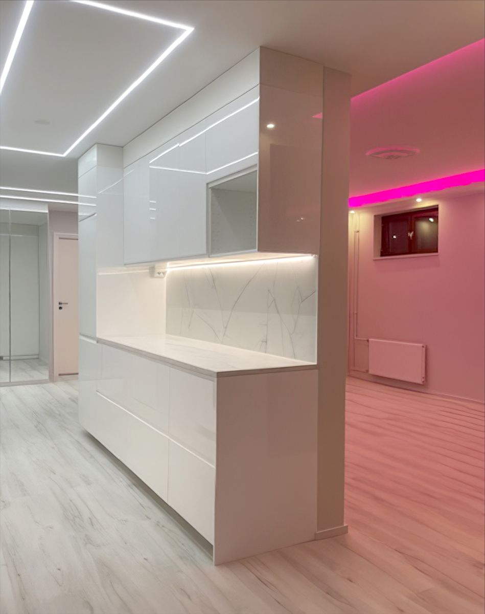 Fyrkantig ljuslinje i kökstaket och rosa led-lampa i vardagsrummet.